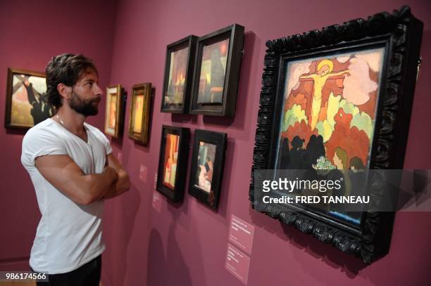 Person looks at "Offrande au calvaire" oil on canvas by French painter Maurice Denis during the exhibition "Le Talisman by Paul Serusier, Une...