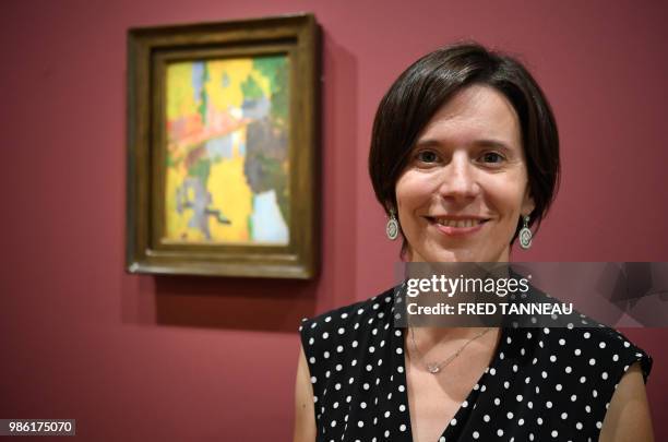 French director and curator of the exhibition Estelle Guille des Buttes poses next to "Le Talisman" 1888 oil on canvas by French painter Paul...