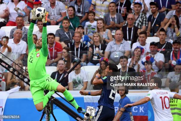 Poland's goalkeeper Lukasz Fabianski jumps to grab the ball past Japan's defender Tomoaki Makino and Poland's midfielder Grzegorz Krychowiak during...