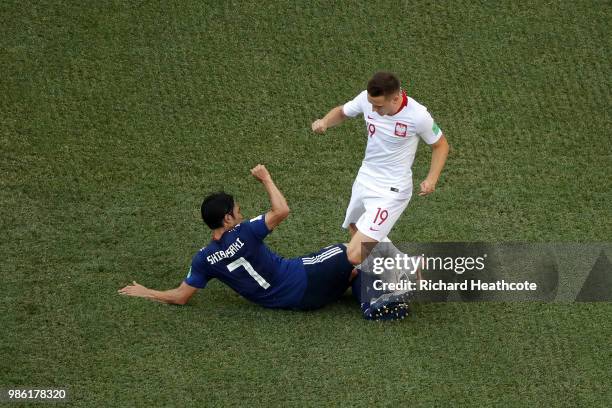 Gaku Shibasaki of Japan tackles Piotr Zielinski of Poland during the 2018 FIFA World Cup Russia group H match between Japan and Poland at Volgograd...