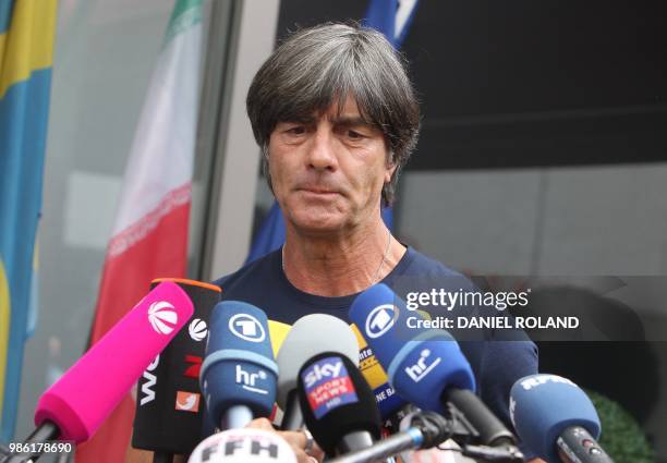 Germany's head coach Joachim Loew talks to media as he arrives at Frankfurt international airport on June 28 after flying back from Moscow following...