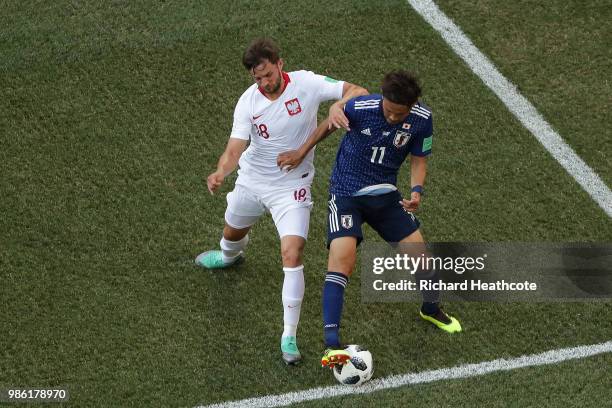 Bartosz Bereszynski of Poland tackles Takashi Usami of Japan during the 2018 FIFA World Cup Russia group H match between Japan and Poland at...