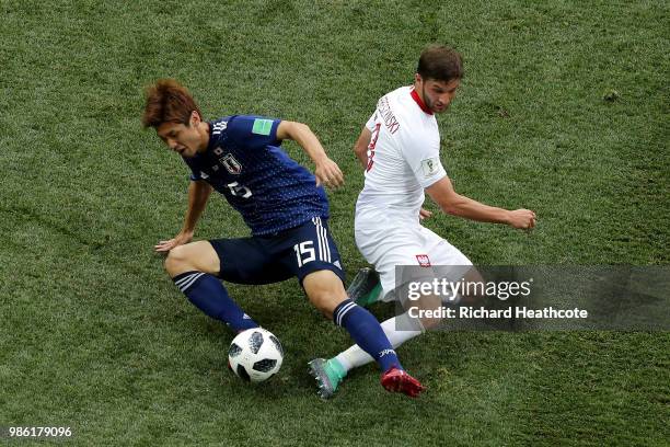 Yuya Osako of Japan is tackled by Bartosz Bereszynski of Poland during the 2018 FIFA World Cup Russia group H match between Japan and Poland at...