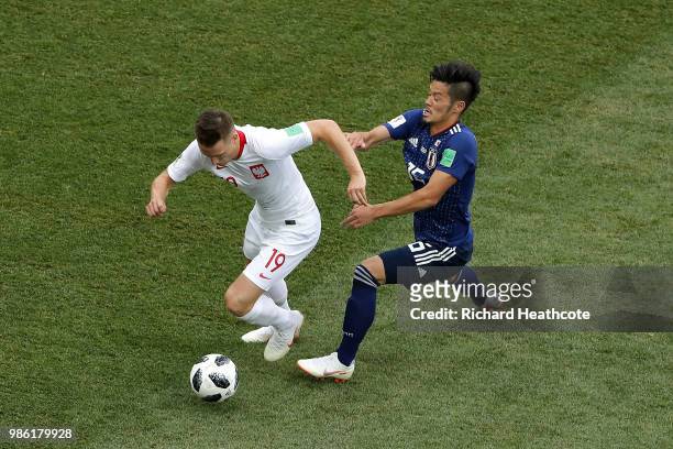 Hotaru Yamaguchi of Japan challenges Piotr Zielinski of Poland during the 2018 FIFA World Cup Russia group H match between Japan and Poland at...