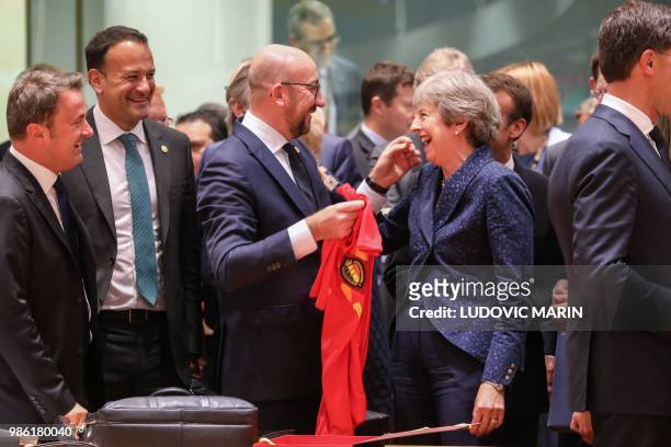 Belgium's Prime Minister Charles Michel offers a jersey of Belgian football national team's forward Eden Hazard to Britain's Prime Minister Theresa...