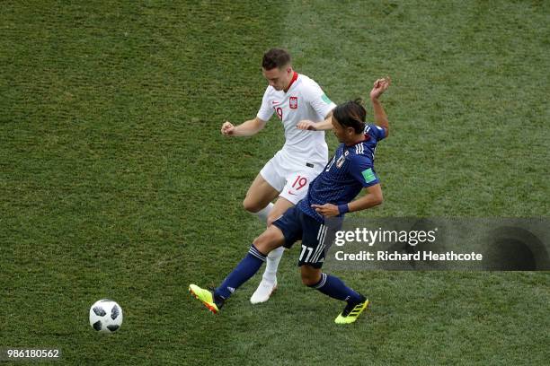 Yuya Osako tackles Piotr Zielinski of Poland during the 2018 FIFA World Cup Russia group H match between Japan and Poland at Volgograd Arena on June...