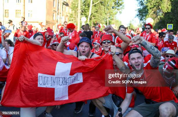 Swiss football fans seen waving and cheering with their national flag before the match. They were among hundreds of Swiss football fans who walked...