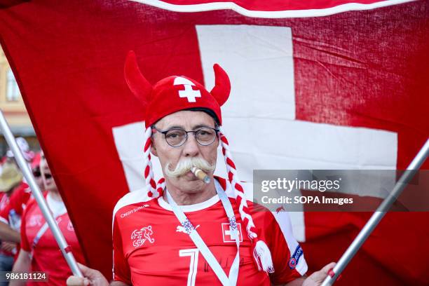 Swiss fan parading with a flag and a fancy dress costume. He was among hundreds of Swiss football fans who walked the streets in the city center...