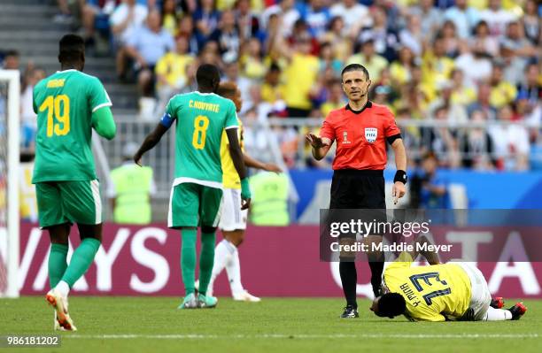 Referee Milorad Mazic talks with Mbaye Niang of Senegal before booking him after a challenge on Yerry Mina of Colombia during the 2018 FIFA World Cup...