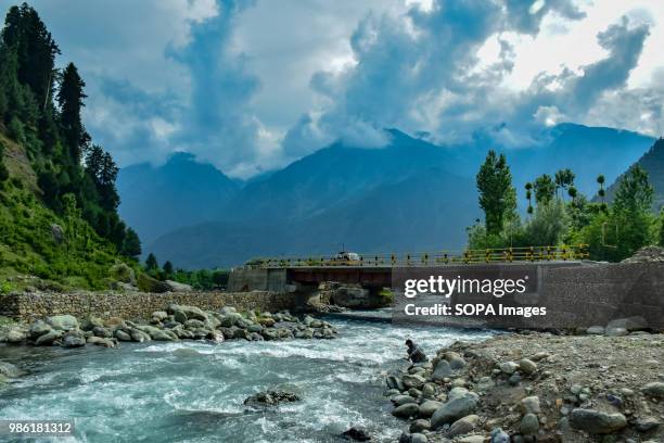 View of Pahalgam along with the river lidder flowing in the middle on a sunny day. Pahalgam is a hill station in the Ananthnag District of Jammu and...