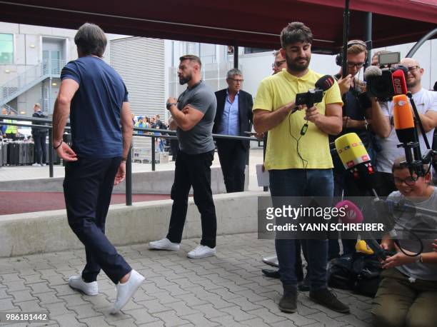 Germany's head coach Joachim Loew leaves after talking to media as he arrives at Frankfurt international airport on June 28 after flying back from...
