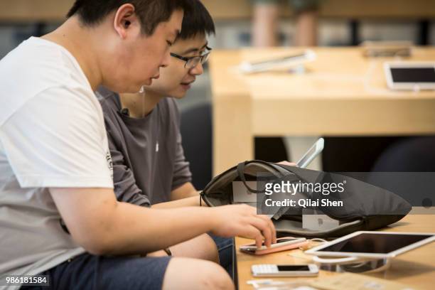 Customers try out Apple Products including Apple Inc.'s iPhone 6s and iPhone 6s Plus ahead of the sales launch at the company's store at the IAPM...