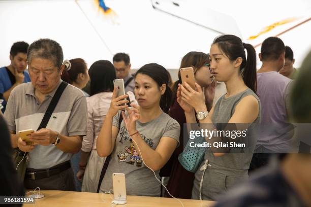 Customers try out Apple Products including Apple Inc.'s iPhone 6s and iPhone 6s Plus ahead of the sales launch at the company's store at the IAPM...