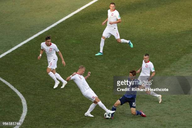 Yuya Osako of Japan competes for the bal with Kamil Glik during the 2018 FIFA World Cup Russia group H match between Japan and Poland at Volgograd...
