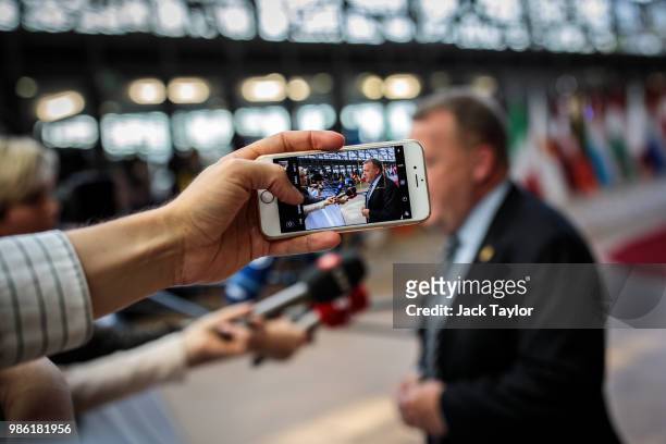 Journalist records a video on her phone as Danish Prime Minister Lars Lokke Rasmussen arrives at the Council of the European Union on the first day...