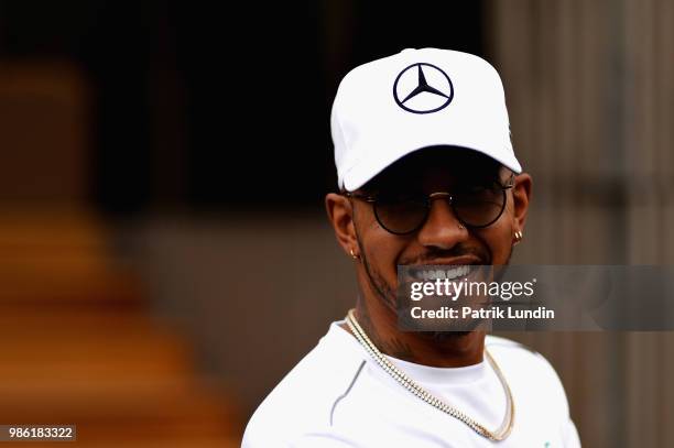 Lewis Hamilton of Great Britain and Mercedes GP looks on in the Paddock during previews ahead of the Formula One Grand Prix of Austria at Red Bull...