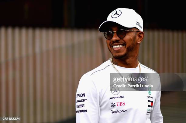Lewis Hamilton of Great Britain and Mercedes GP looks on in the Paddock during previews ahead of the Formula One Grand Prix of Austria at Red Bull...