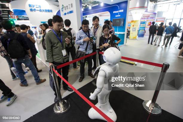 Visitors take pictures of a robot while attending the 2015 Computing Conference in Hangzhou, China, on Wednesday, Oct. 14, 2015. Alibaba Group...