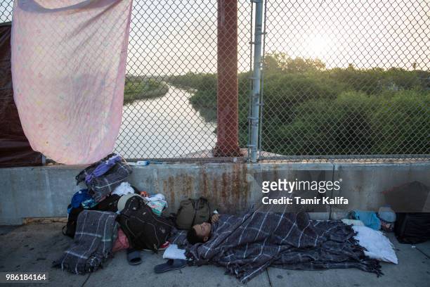 Year-old boy from Honduras sleeps on the Mexican side of the Brownsville & Matamoros International Bridge, where he and his family have been waiting...
