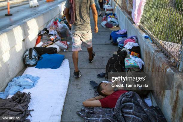 Year-old boy from Honduras sleeps on the Mexican side of the Brownsville & Matamoros International Bridge, where he and his family have been waiting...