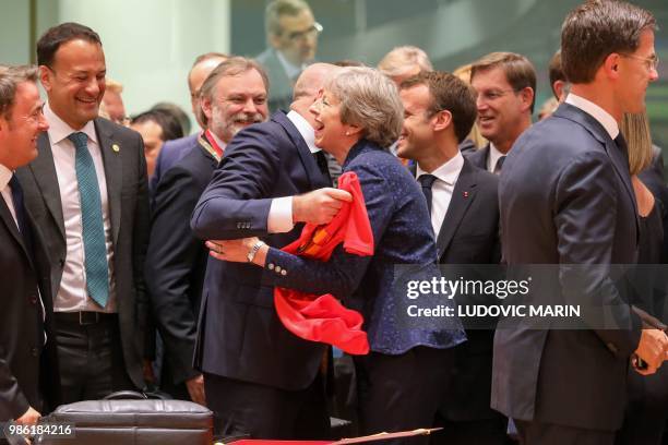 Belgium's Prime Minister Charles Michel offers a jersey of Belgian football national team's forward Eden Hazard to Britain's Prime Minister Theresa...