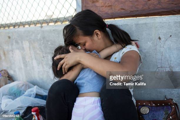 Honduran woman embraces her 2-year-old daughter as they wait on the Mexican side of the Brownsville & Matamoros International Bridge after being...