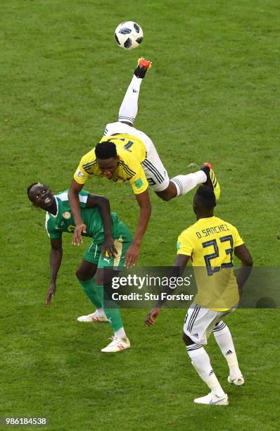 Yerry Mina of Colombia goes airborne under a challenge from Sadio Mane of Senegal as Davinson Sanchez looks on during the 2018 FIFA World Cup Russia...