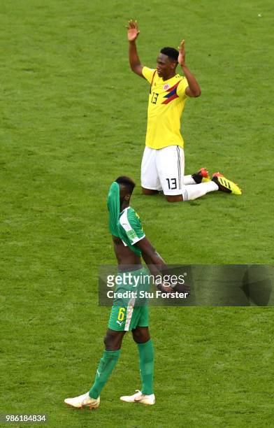 Salif Sane of Senegal looks dejected as Yerry Mina of Colombia celebrates following his sides victory in the 2018 FIFA World Cup Russia group H match...