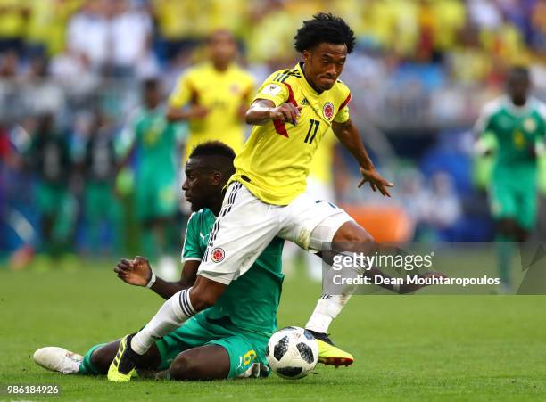 Juan Cuadrado of Colombia is challenged by Salif Sane of Senegal during the 2018 FIFA World Cup Russia group H match between Senegal and Colombia at...