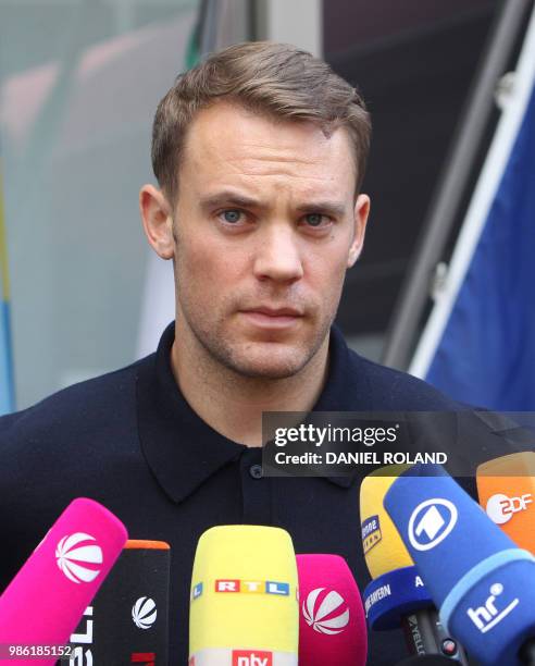 Germany's goalkeeper Manuel Neuer talks to media as he arrives at Frankfurt international airport on June 28 after flying back from Moscow following...