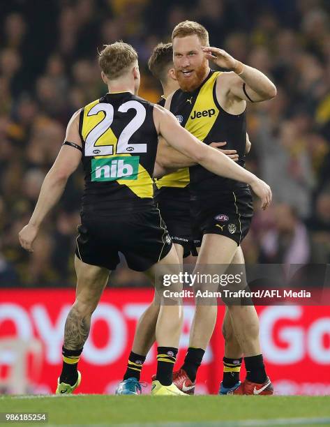 Nick Vlastuin of the Tigers celebrates a goal with Josh Caddy and Jayden Short of the Tigers during the 2018 AFL round 15 match between the Richmond...