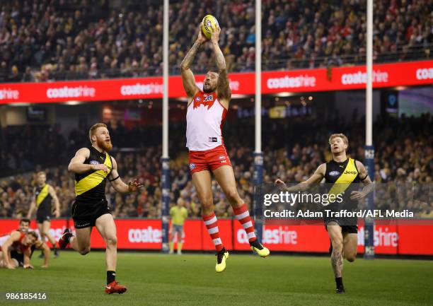 Lance Franklin of the Swans marks the ball ahead of Nick Vlastuin and Nathan Broad of the Tigers during the 2018 AFL round 15 match between the...