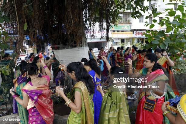 Hindu women tying threads and performing puja around the Banyan tree on the occasion of Vat Purnima at Warje Madwadi, on June 27, 2018 in Pune,...