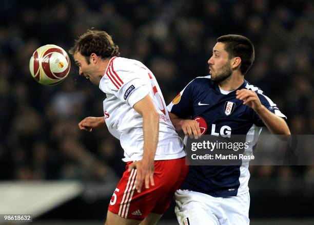 Joris Mathijsen of HSV and Clint Dempsey of Fulham jump for a header during the UEFA Europa League semi final first leg match between Hamburger SV...