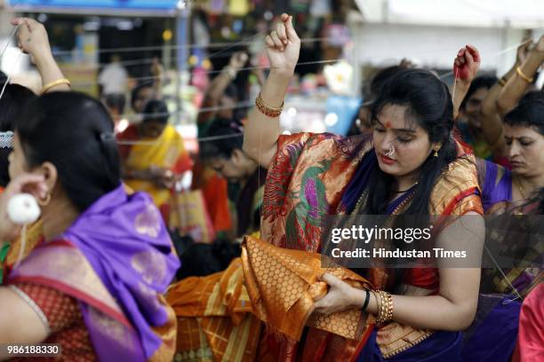 Hindu devotee women tying threads and performing puja around the Banyan tree on the occasion of Vat Purnima at Warje Madwadi, on June 27, 2018 in...