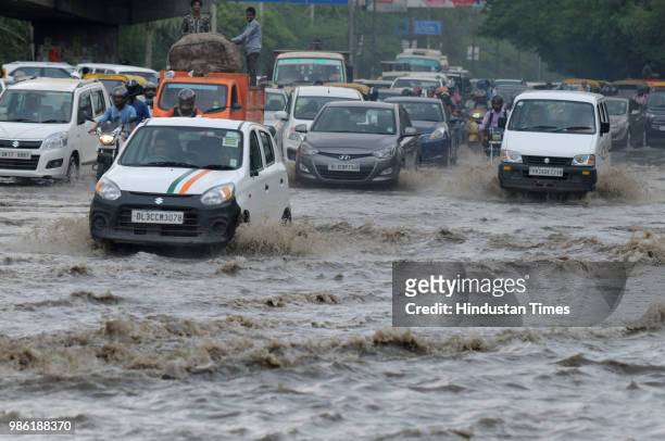 Vehicles wade thorough a waterlogged road after the heavy pre-monsoon rain at Maharana Pratap Chowk, on June 28, 2018 in Gurugram, India. Delhi and...