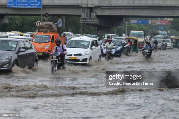 Vehicles wade thorough a waterlogged road after the heavy pre-monsoon rain at Maharana Pratap Chowk, on June 28, 2018 in Gurugram, India. Delhi and...