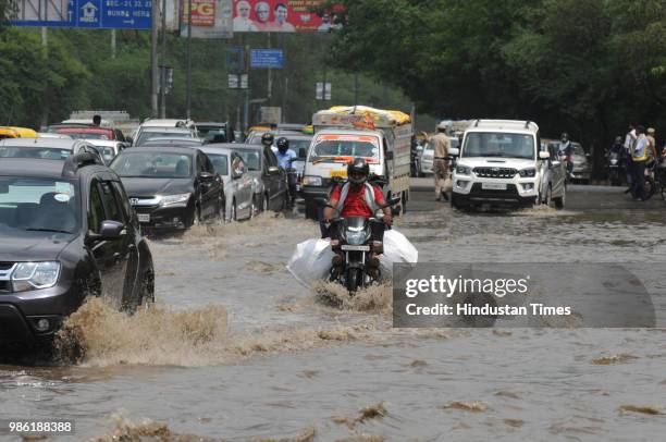 Vehicles wade thorough a waterlogged road after the heavy pre-monsoon rain at Maharana Pratap Chowk, on June 28, 2018 in Gurugram, India. Delhi and...