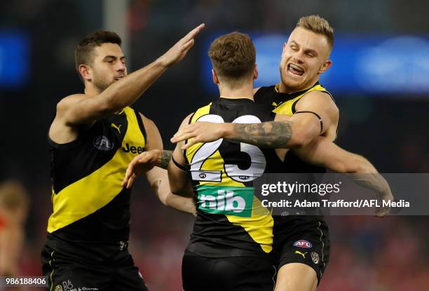 Kane Lambert of the Tigers celebrates a goal with Jack Graham and Brandon Ellis of the Tigers during the 2018 AFL round 15 match between the Richmond...
