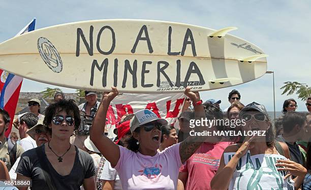 Woman holds a surfboard with the sentence "Not to mining industry" April 22 in San Jose during a protest against a resolution by the Costa Rican...