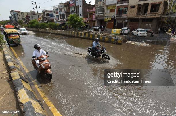 Vehicles wade through waterlogged road, after heavy rain at Sector 58, on June 28, 2018 in Noida, India. Delhi and National Capital Regions witnessed...