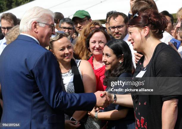 June 2018, Germany, Berlin: German President Frank-Walter Steinmeier speaking with guests during a reception for around 600 fellowship holders of the...