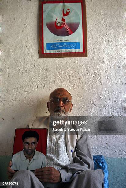 Year-old Haji Sher Ali Bhat holds a picture of his 41-year-old son Mohd Ali Bhat at his home on April 22, 2010 in Srinagar, Kashmir, India. Ali was...