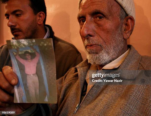 Relative of Mirza Nissar Hussain who was sentenced to death after being convicted in the Delhi bomb blast trial holds his picture at his home on...