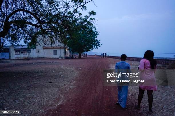 People walk along the corniche of Segou, Mali. The corniche is lined by colonial era buildings often connected with the Office Du Niger project.