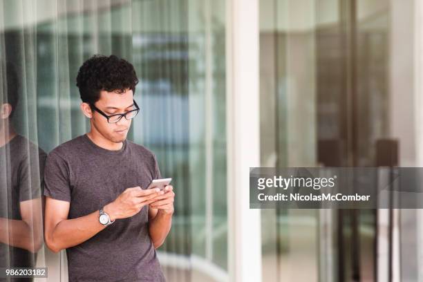young asian man sms en plein air en milieu urbain - sms'en photos et images de collection