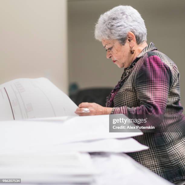 mujer de pelo plateado senior, ingeniero, trabajando con el proyecto arquitectónico - alex potemkin or krakozawr fotografías e imágenes de stock