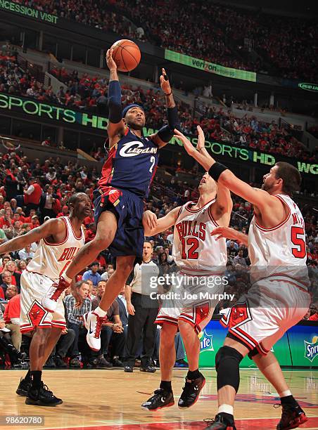 Mo Williams of the Cleveland Cavaliers goes the basket over James Johnson, Kirk Hinrich and Brad Miller of the Chicago Bulls in Game Three of the...