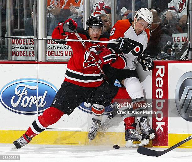 Darroll Powe of the Philadelphia Flyers is checked hard into the boards by Dainius Zubrus of the New Jersey Devils in Game Five of the Eastern...