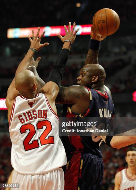 Shaquille O'Neal of the Cleveland Cavaliers passes the ball behind his head under pressure from Taj Gibson of the Chicago Bulls in Game Three of the...